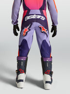 Alpinestars Pantaloni Fluid Hunt Ragazzo, pantaloni da motocross fuoristrada, viola e rosa, loghi a stella rossi e scritta astars bianca, costruzione in poliestere resistente, vista posteriore su modello.