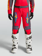 Alpinestars Pantaloni Fluid Hunt Ragazzo, pantaloni da motocross rossi e grigi per guida off-road, design ergonomico in tessuto poliestere con grafiche blu e arancioni, abbigliamento tecnico per giovani piloti.