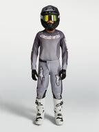 Alpinestars Pantaloni Fluid Amber Ragazzo 2027, pantaloni da motocross grigi e sabbia in poliestere 600D, vestibilità sportiva per off-road, indossati con attrezzatura coordinata