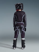 Vista posteriore di un giovane pilota di motocross che indossa i pantaloni Alpinestars 2026 Youth Fluid Apex in nero e grigio, maglia a maniche lunghe coordinata, casco nero e stivali da motocross bianchi e neri, abbigliamento da gara off-road coordinato.