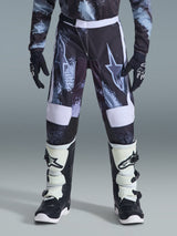 Alpinestars 2026 Youth Fluid Lahnd Pants, pantaloni da motocross per ragazzi, Iron Camo con accenti bianchi, indossati con stivali e guanti da off-road bianchi e neri, design resistente per giovani piloti