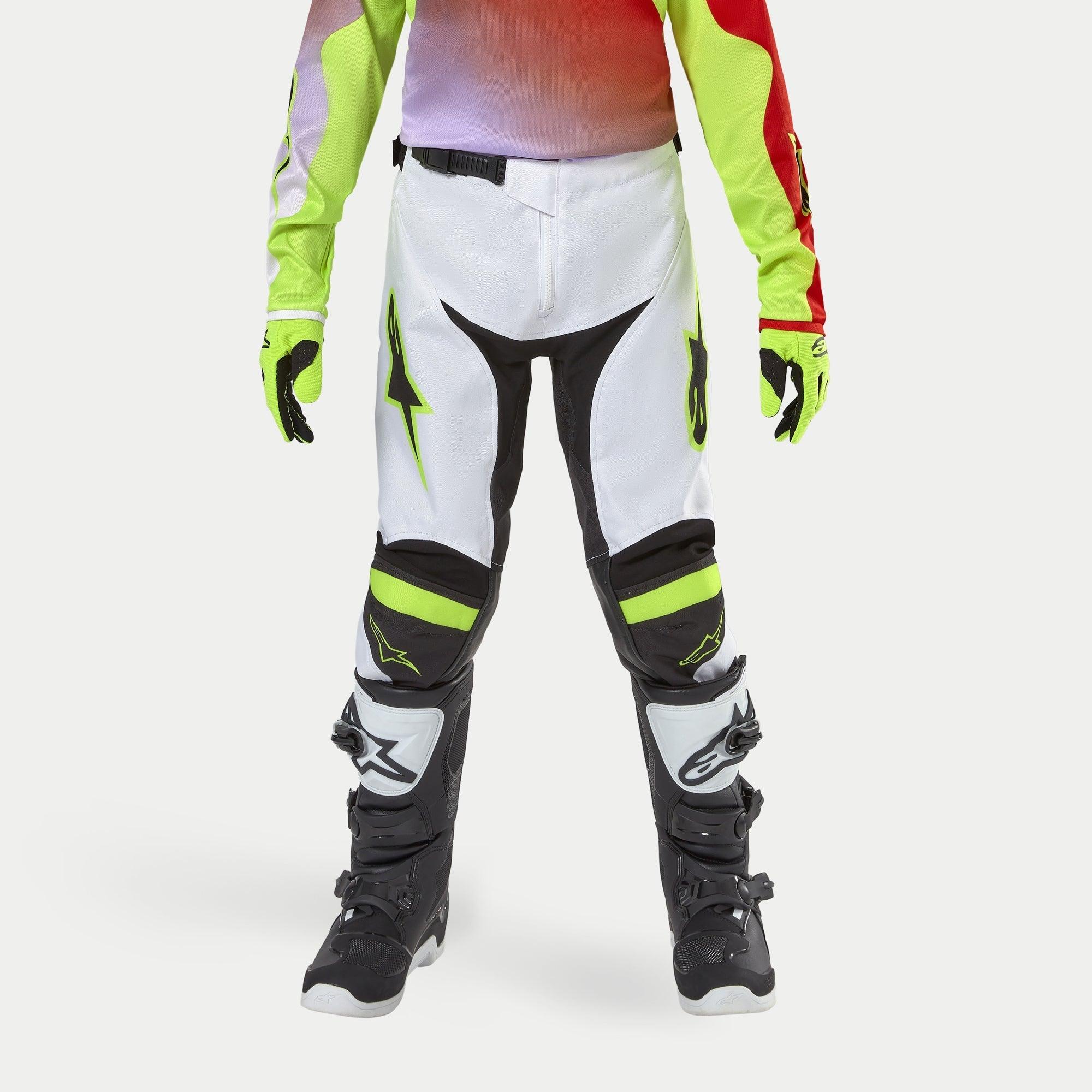 Alpinestars pantaloni Youth Racer Lucent 2024, pantaloni da motocross, bianco con accenti giallo neon e nero, indossati con guanti neon coordinati e stivali neri, con gambe pre-curvate ergonomiche e loghi Alpinestars, equipaggiamento ad alte prestazioni per corse fuoristrada