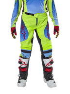 Alpinestars pantaloni Youth Racer Hoen 2024, pantaloni da motocross, giallo fluo e blu navy, con loghi a stella rossi sulle cosce, indossati con maglia coordinata, guanti rossi e neri e stivali da motocross bianchi, neri e rossi, equipaggiamento resistente per il fuoristrada