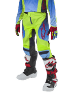 Pantaloni Alpinestars Youth 2024 Racer Hoen, pantaloni da motocross, giallo fluo e blu notte con dettagli rossi, indossati con guanti coordinati e stivali bianchi, neri e rossi, con vestibilità sportiva e gambe pre-curvate per il fuoristrada