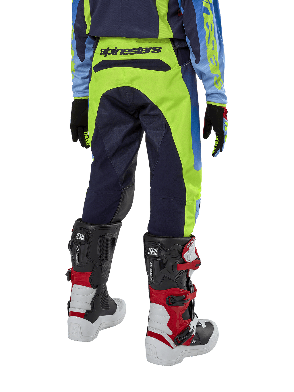 Alpinestars Youth 2024 Racer Hoen Pants, pantaloni da motocross, giallo fluo e blu night navy, vista posteriore con evidente marchio Alpinestars sulla fascia in vita, indossati con stivali Tech Series neri e rossi e maglia coordinata, vestibilità sportiva per fuoristrada ragazzi