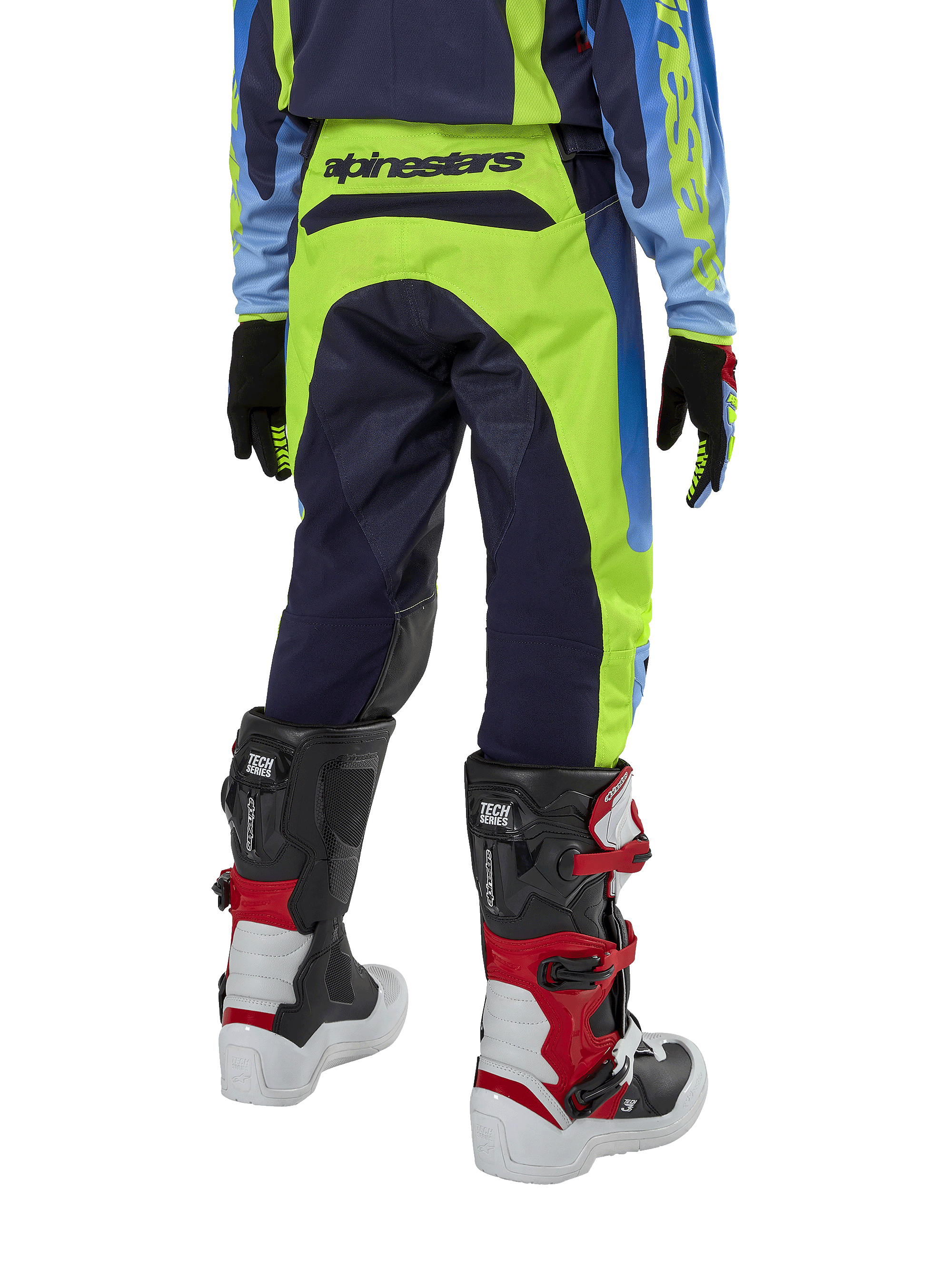 Alpinestars Youth 2024 Racer Hoen Pants, pantaloni da motocross, giallo fluo e blu night navy, vista posteriore con evidente marchio Alpinestars sulla fascia in vita, indossati con stivali Tech Series neri e rossi e maglia coordinata, vestibilità sportiva per fuoristrada ragazzi