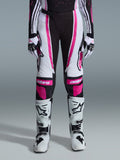 Pantaloni Alpinestars 2026 Stella Techstar Nomur Donna, pantaloni da motocross, nero, bianco e fucsia, indossati con maglia da gara coordinata, guanti e stivali da motocross bianchi, caratterizzati da audaci grafiche rosa e loghi astars sulle ginocchia, progettati per competizioni fuoristrada di alto livello.