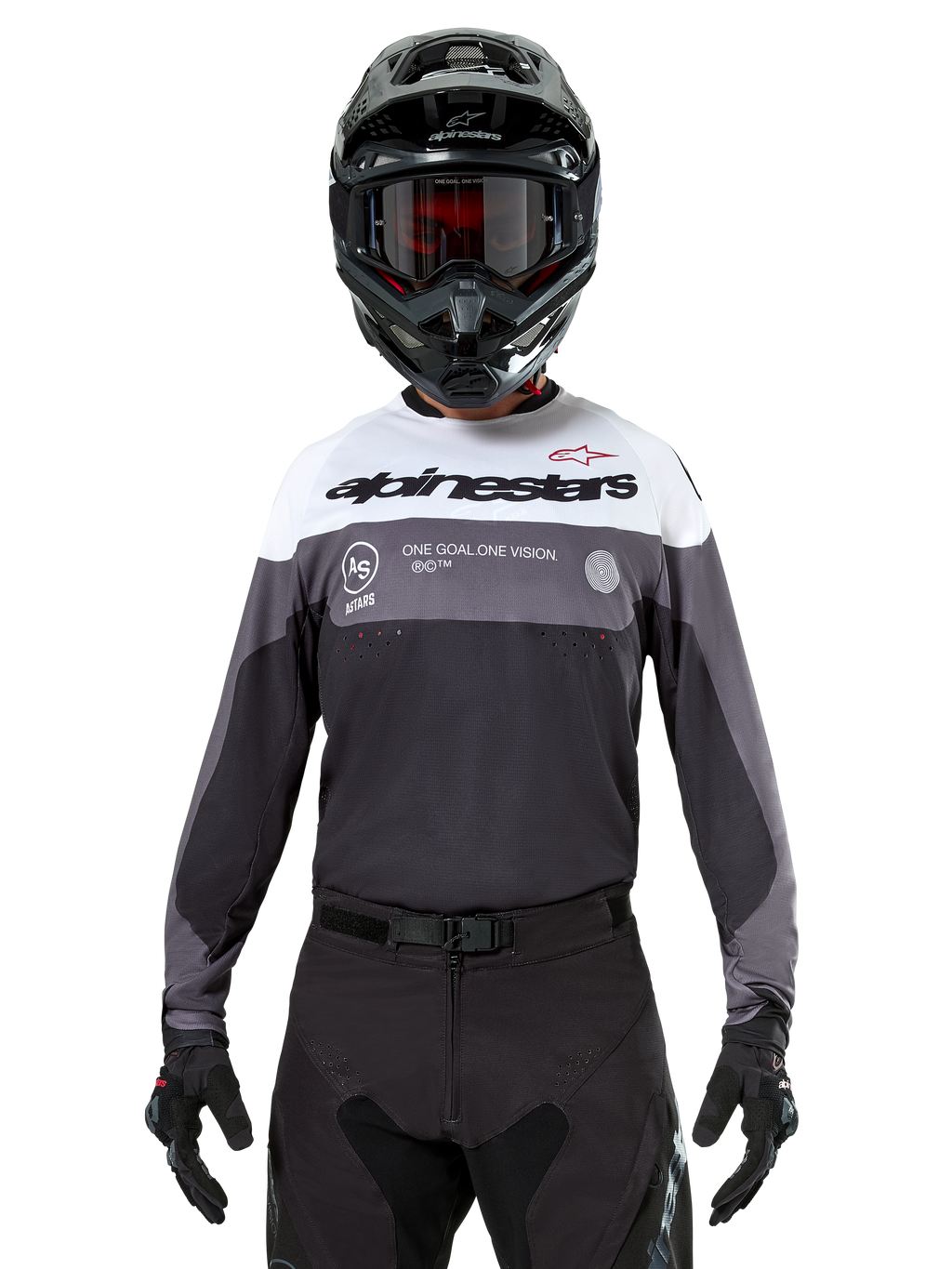 Pilota di motocross con maglia Alpinestars Pro-Dura in Black Magnet White, maglia tecnica a maniche lunghe con inserti bianchi e grigi, indossata con casco e occhiali neri, con logo 'alpinestars' e slogan 'ONE GOAL ONE VISION', abbigliamento da moto off-road