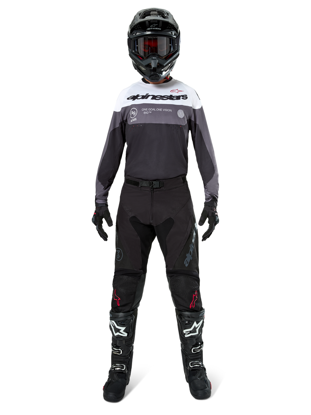 Pilota di motocross con equipaggiamento da gara completo, maglia Pro-Dura in Black Magnet White con parte superiore del petto bianca e dettagli grigi, abbinata a pantaloni neri, casco nero con maschera scura, stivali bianchi e neri e guanti neri, outfit coordinato per enduro e fuoristrada