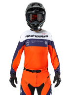 Maglia Alpinestars Pro-Dura, maglia da motocross, blu navy, arancione acceso e bianco, indossata con casco e guanti neri, con zone di ventilazione traforate al laser, branding audace e grafica sul petto "ONE GOAL. ONE VISION."