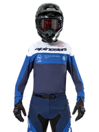 Alpinestars Pro-Dura Jersey, maglia da motocross ed enduro, blu navy, blu brillante e bianco, indossata con pantaloni coordinati, guanti e casco neri, con logo sul petto e fori di ventilazione laser per corse off-road