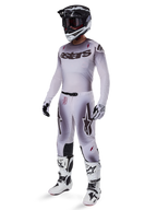 Set completo Alpinestars Supertech Maker 2025, abbigliamento completo da motocross, sfumatura bianca e grigia con branding nero e accenti rossi, include casco con maschera, maglia, pantaloni, stivali bianchi e guanti, design aerodinamico orientato alle prestazioni per gare fuoristrada