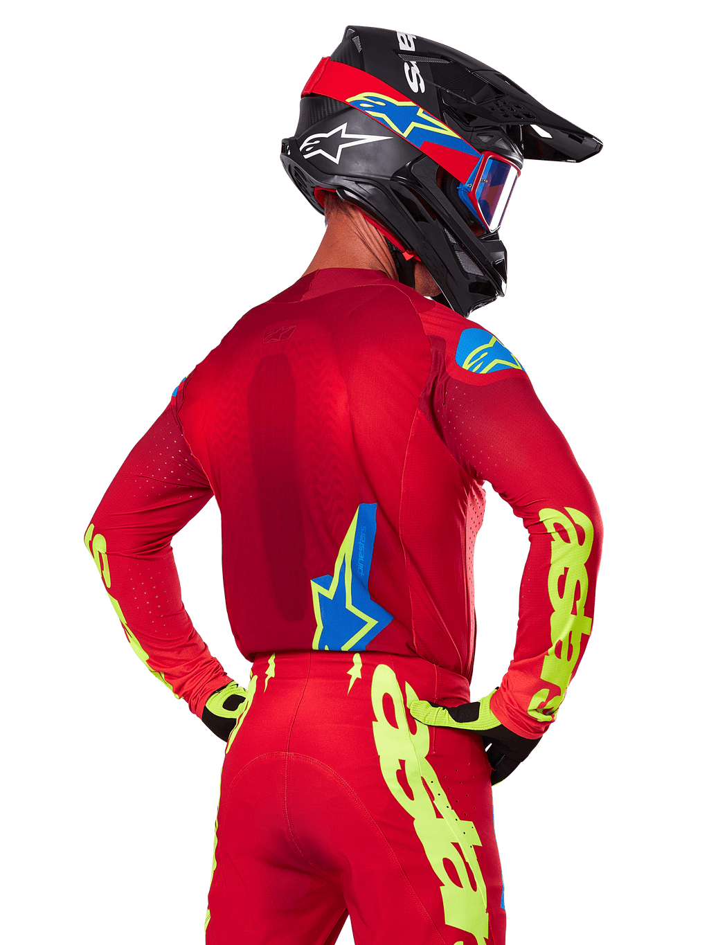 Vista posteriore di un pilota di motocross che indossa il set Alpinestars 2025 Supertech Maker in rosso, caratterizzato da una maglia rossa con grafica giallo neon sulle maniche, pantaloni rossi coordinati, un casco nero con accenti blu e rossi e guanti neri e gialli coordinati.