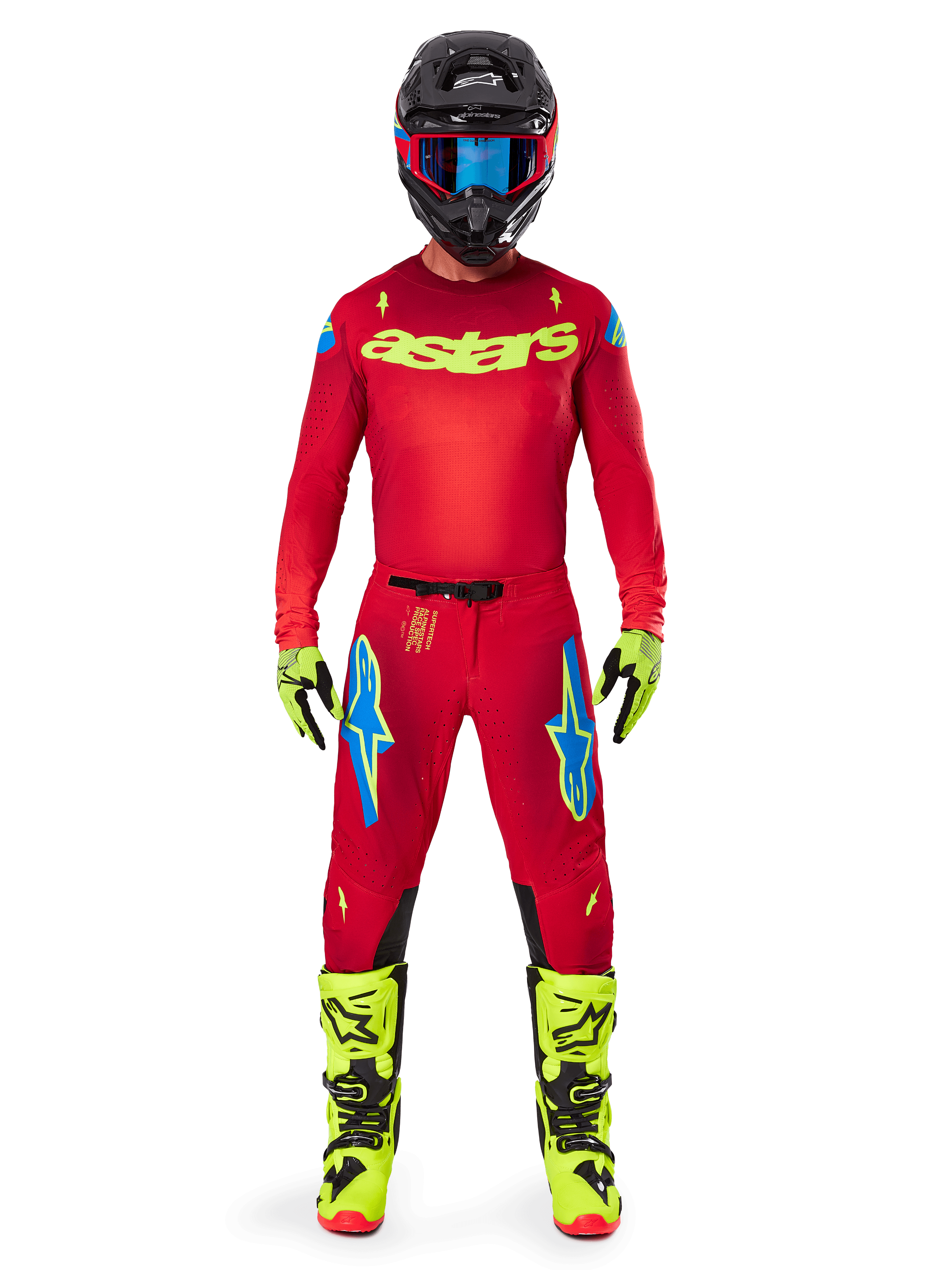 Pilota di motocross con maglia Alpinestars 2025 Supertech Maker e pantaloni coordinati in Rosso Acceso e Giallo Fluo, logo 'astars' giallo sul petto, casco nero con occhiali blu, guanti e stivali giallo fluo, completo professionale da gara per prestazioni fuoristrada