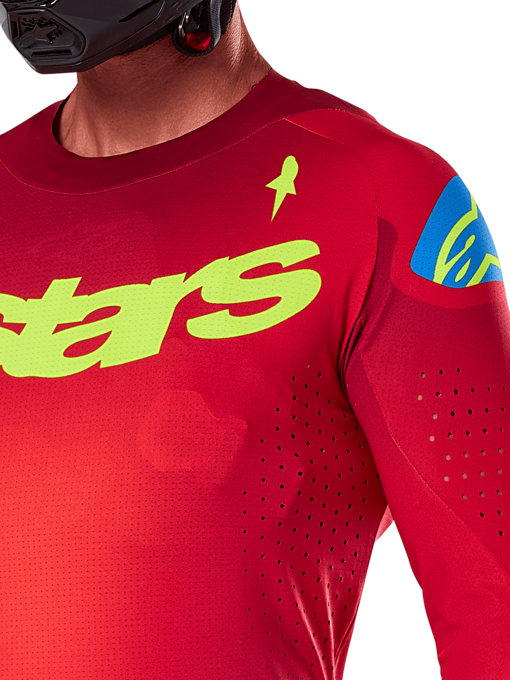 Alpinestars 2025 Supertech Maker Jersey, maglia da motocross, rosso acceso e giallo fluo, vista ravvicinata con perforazioni tagliate al laser, marchio Alpinestars giallo sul petto, dettaglio blu sulla spalla, tessuto a rete elasticizzato traspirante
