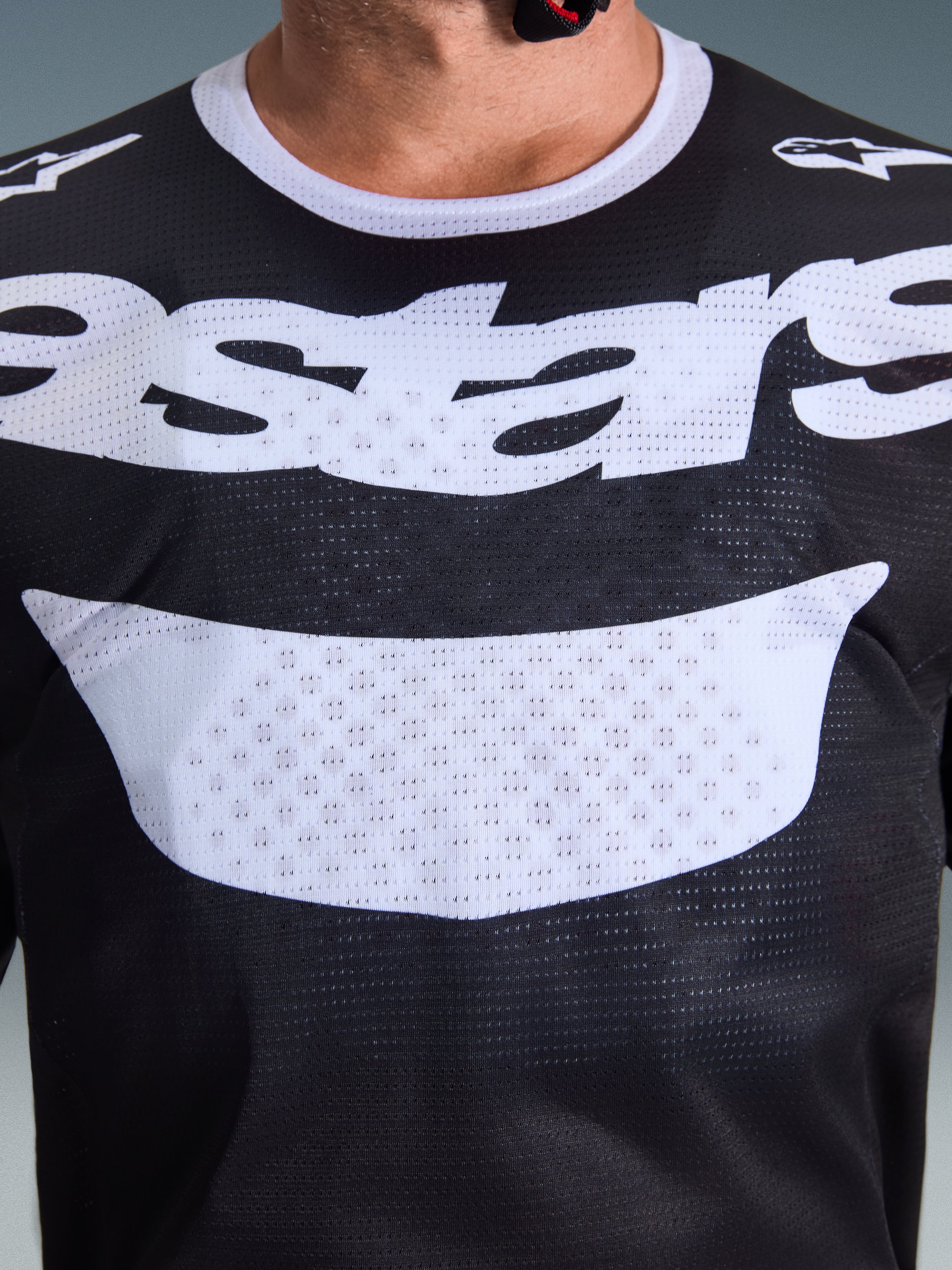 Alpinestars 2026 Racer Air Riway Jersey, maglia da motocross, nero e bianco, vista ravvicinata del torace con grande logo bianco, trama dettagliata del tessuto mesh traspirante, abbigliamento tecnico per guida off-road
