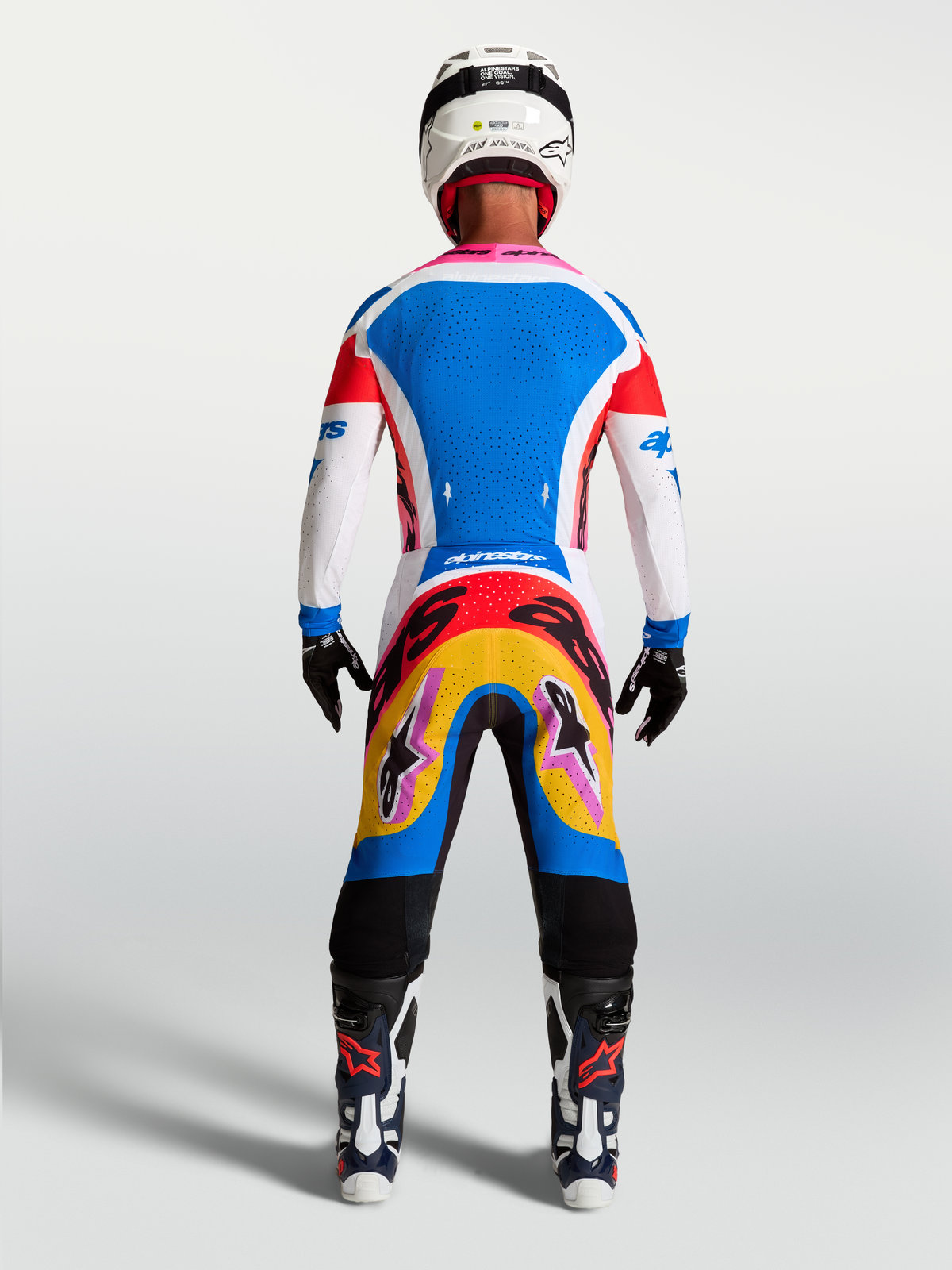 Alpinestars maglia Supertech Dyna e completo da motocross blu e bianco con accenti rosa, vista posteriore su modello.
