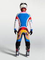Alpinestars maglia Supertech Dyna e completo da motocross blu e bianco con accenti rosa, vista posteriore su modello.