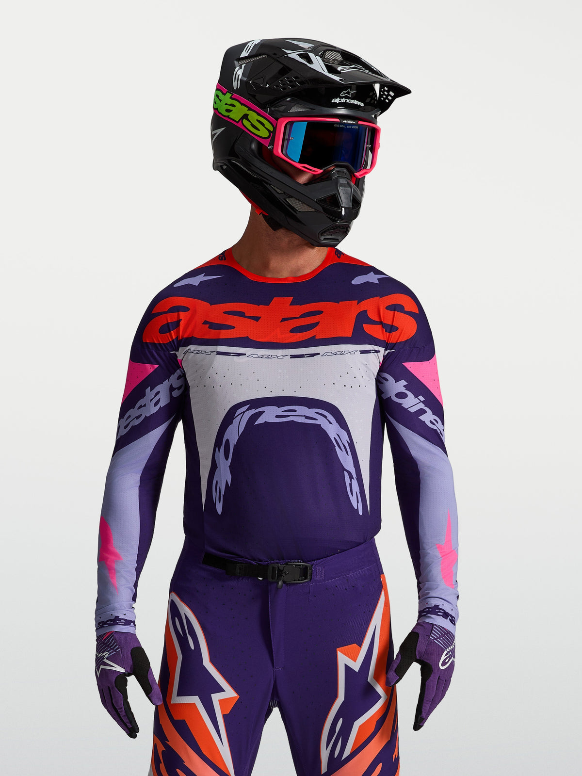 Alpinestars Maglia Supertech Dyna, maglia da motocross da uomo viola e rosa fluo, vestibilità atletica racing in mesh, indossata da un pilota.
