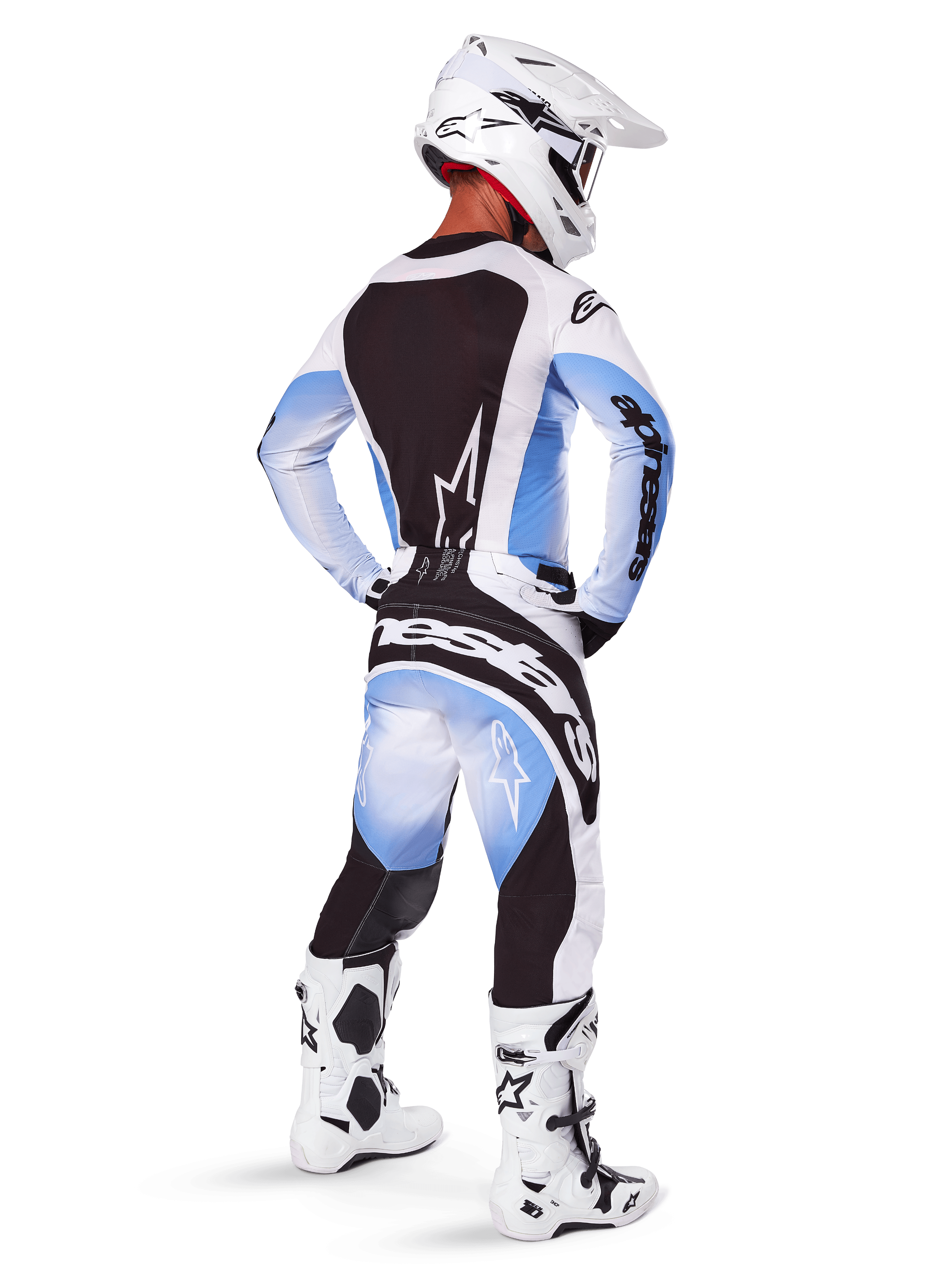 Pilota di motocross con abbigliamento completo da gara, set 2025 Techstar Melt, maglia bianca e azzurra con pannello posteriore nero, pantaloni coordinati con sfumatura blu e accenti neri, casco bianco, stivali bianchi e neri, completo coordinato per gare off-road