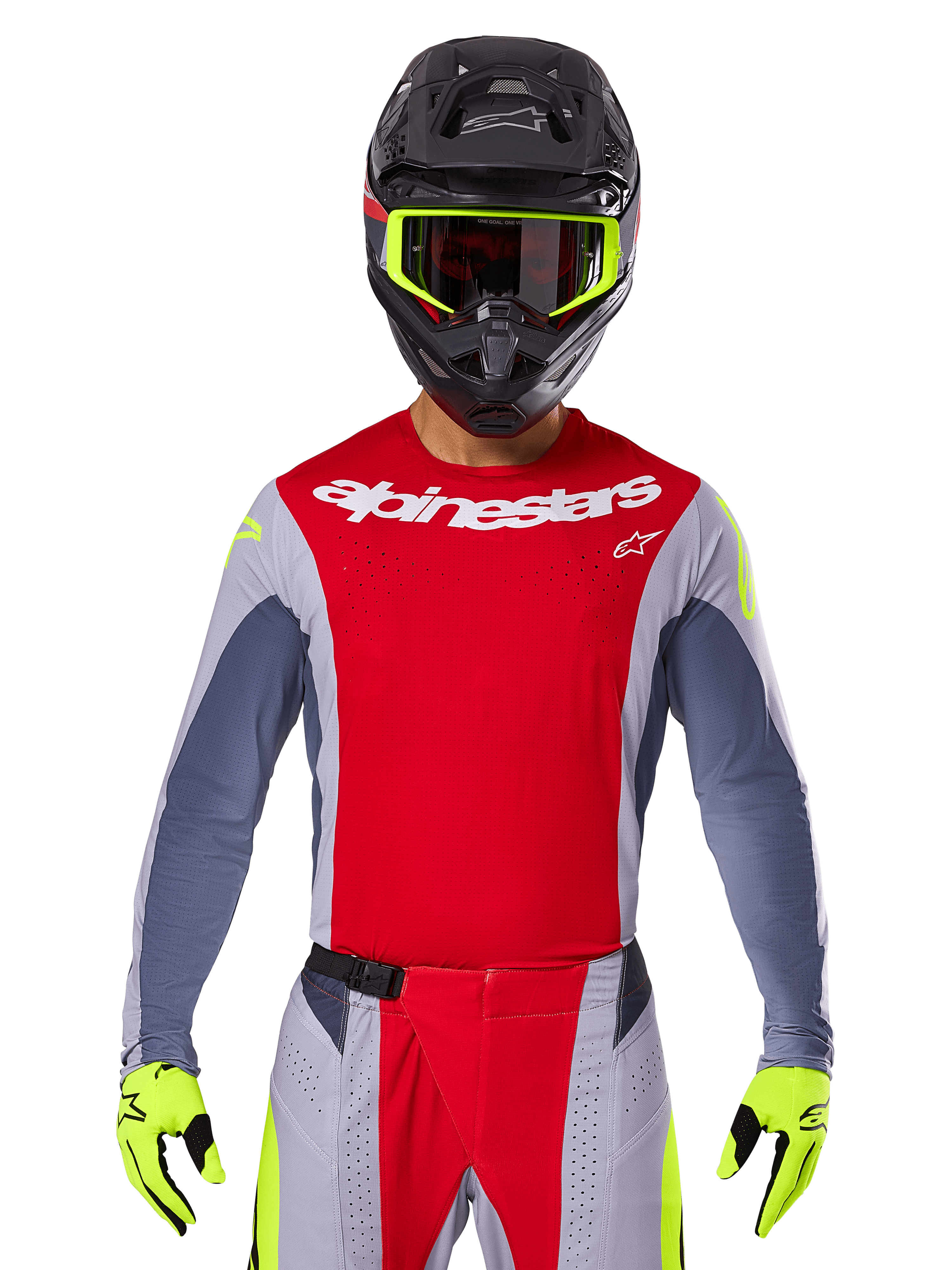 Pilota di motocross che indossa la maglia e i pantaloni coordinati Techstar Melt 2025, rosso acceso e grigio con branding Alpinestars bianco, casco nero con maschera giallo neon, guanti giallo neon coordinati, abbigliamento tecnico ventilato per gare fuoristrada