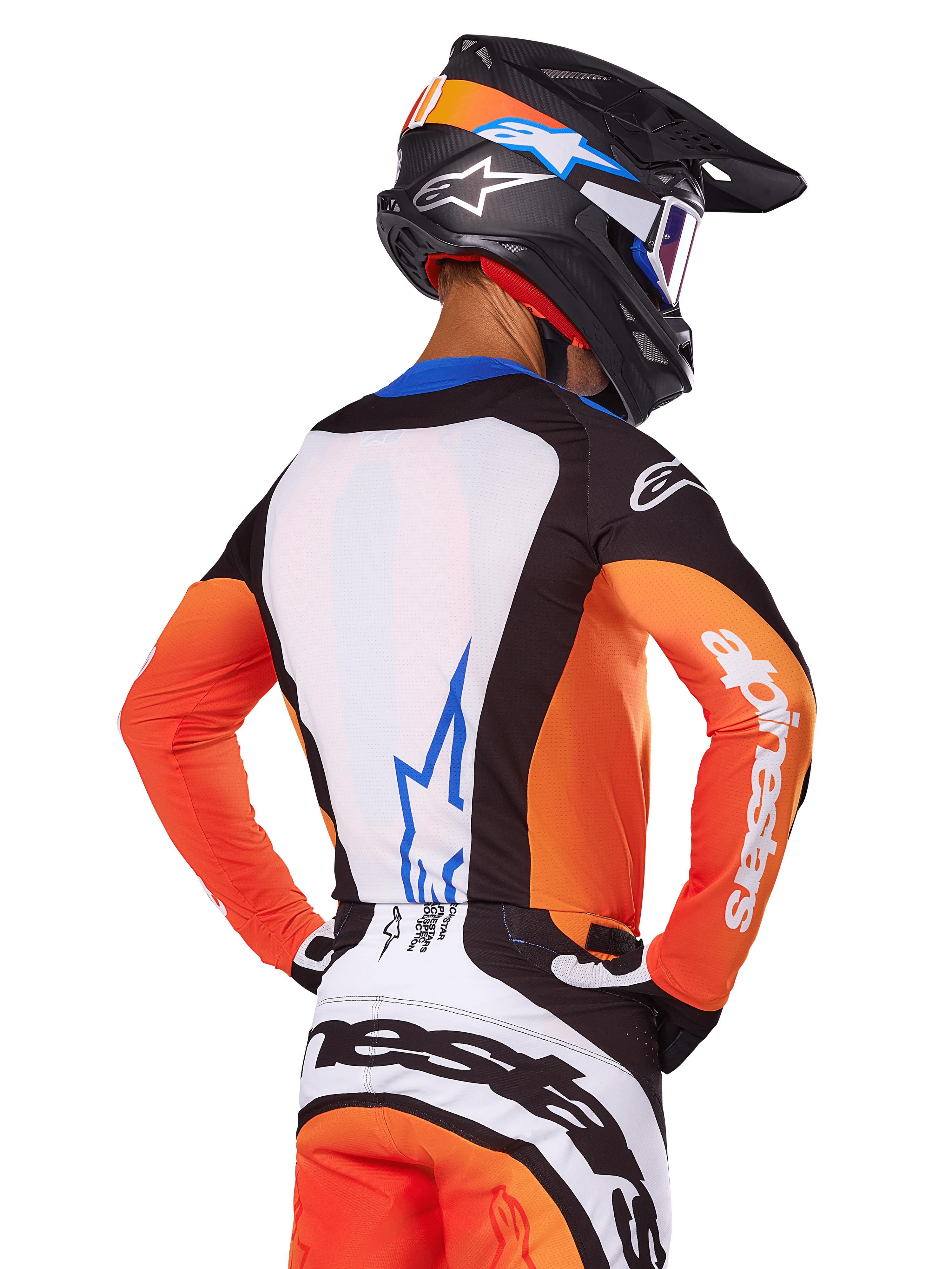 Pilota di motocross con maglia Alpinestars 2025 Techstar Melt, arancione e blu, vista posteriore con pannello bianco e logo blu, maniche arancioni con marchio bianco, casco e pantaloni coordinati, abbigliamento da gara professionale