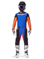 Alpinestars 2025 Techstar Melt Gear Set, pilota di motocross che indossa maglia arancione e blu con dettagli neri, pantaloni coordinati, casco nero con occhiali blu, stivali bianchi e neri, completo coordinato per competizioni fuoristrada professionali.