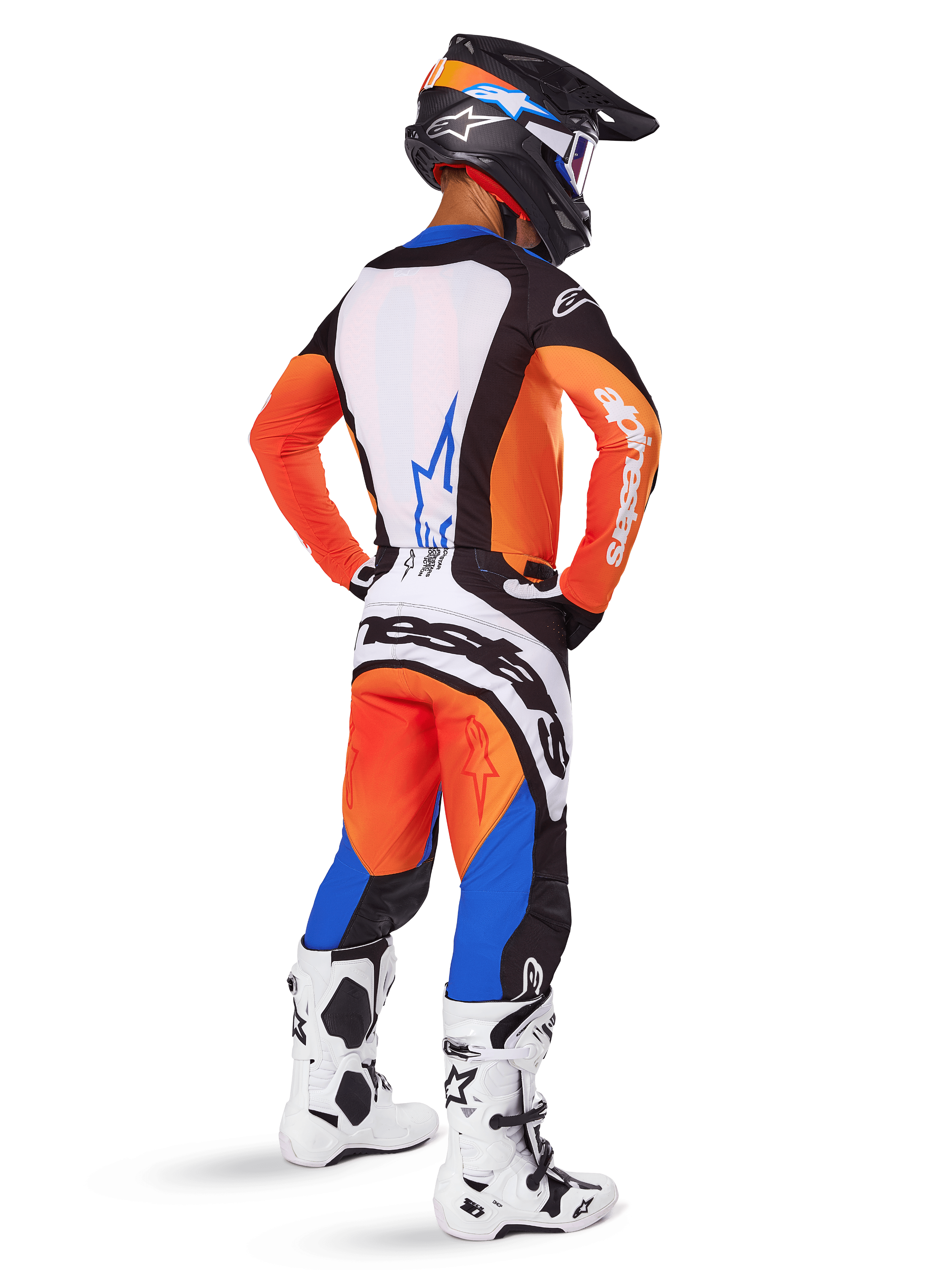 Pilota di motocross visto da dietro che indossa il Set Gear Techstar Melt 2025, maglia arancione e blu con pannello posteriore bianco e logo a stella blu, pantaloni coordinati arancioni e blu con marchio Alpinestars bianco, casco nero con grafiche blu e stivali da motocross bianchi, completo da gara fuoristrada coordinato.