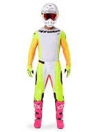 Alpinestars 2025 Techstar Melt Jersey, pilota di motocross con abbigliamento completo, maglia bianca e gialla con maniche arancioni, pantaloni gialli coordinati, stivali rosa acceso, casco bianco con occhiali rossi, kit da gara off-road coordinato