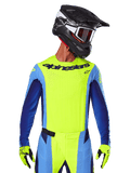Alpinestars 2025 Techstar Melt Jersey, maglia da motocross, giallo fluo e blu, con ventilazione tagliata al laser e vestibilità atletica da gara, indossata da un pilota con casco nero e guanti giallo fluo