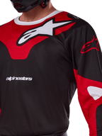 Maglia Alpinestars Racer Veil 2025, maglia da motocross, nero e rosso vivace, primo piano con grande logo Astars bianco su un pannello rosso sul petto, scritta del marchio bianca e tessuto tecnico traspirante.