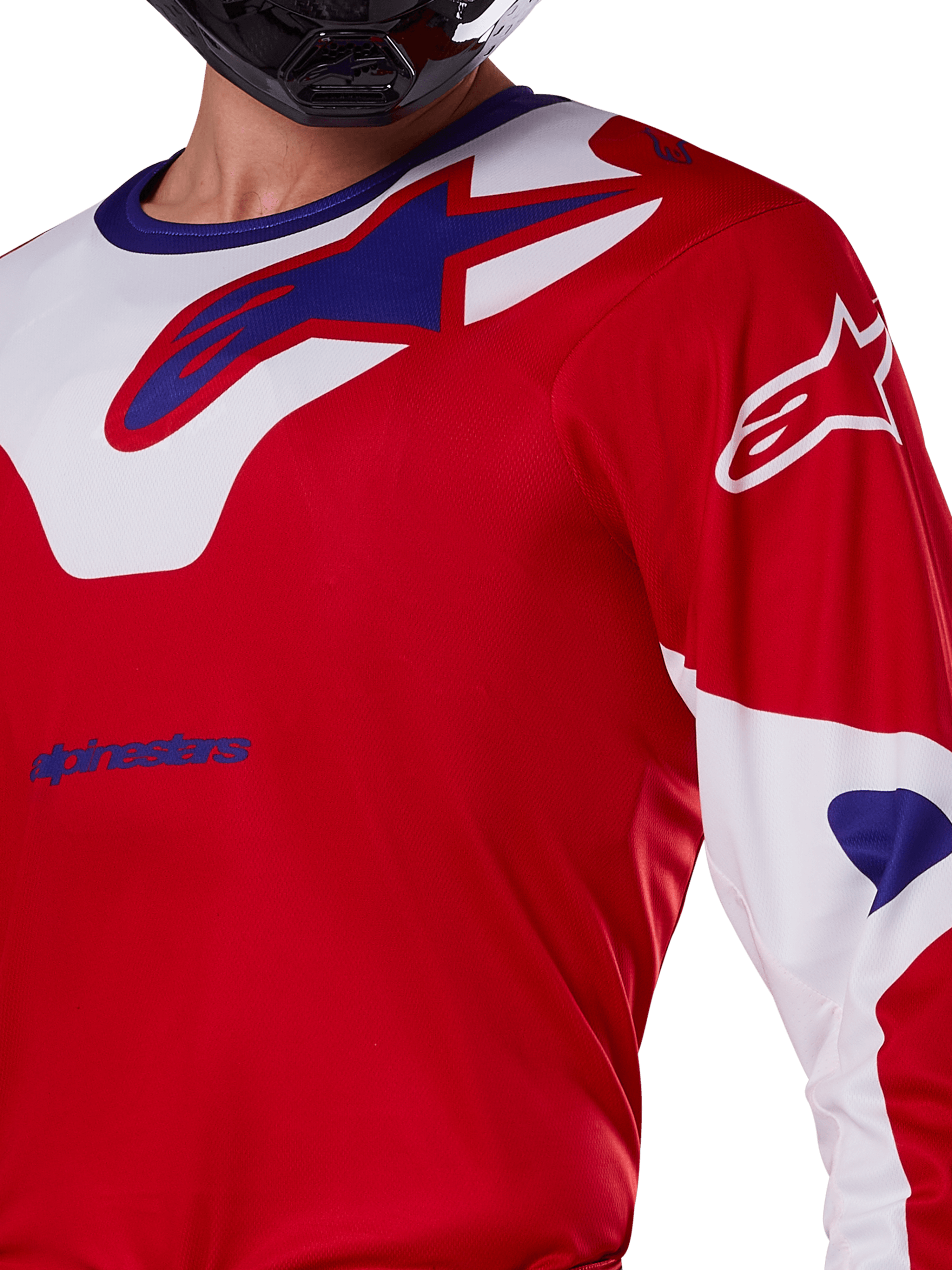 Alpinestars 2025 Racer Veil Jersey, maglia da motocross, rosso brillante e bianco, vista ravvicinata della parte superiore del busto e del petto, logo Alpinestars blu su inserto del colletto bianco, maniche rosse con accenti bianchi, indossata con un casco nero, abbigliamento tecnico da fuoristrada