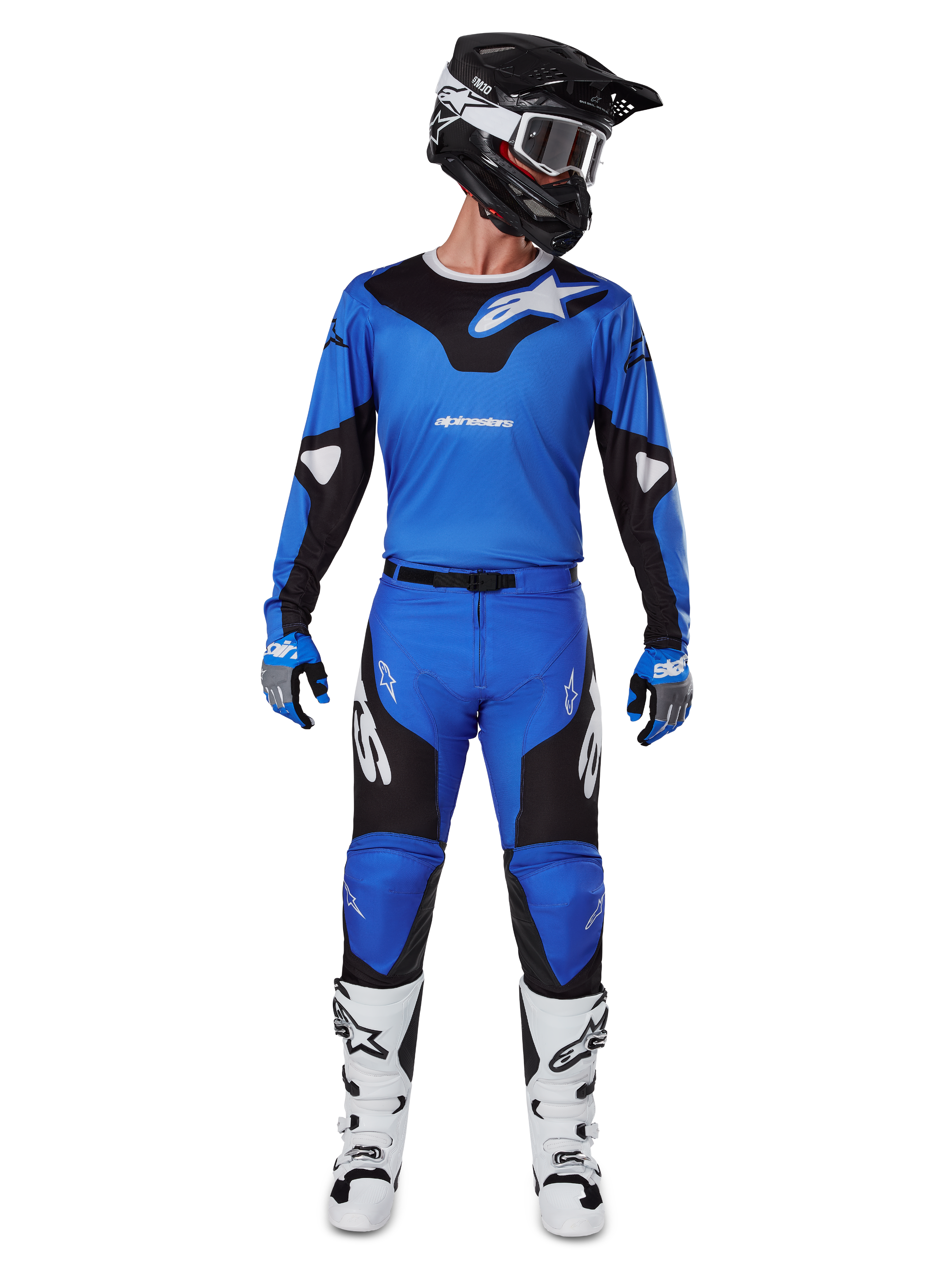 Pilota di motocross con set Alpinestars 2025 Racer Veil Gear, maglia blu e nera con pantaloni abbinati, casco nero con occhiali bianchi, stivali bianchi e neri, abbigliamento da gara coordinato per motocross fuoristrada