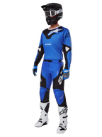 Set completo Alpinestars Racer Veil 2025, maglia e pantaloni da motocross blu e neri, abbigliamento completo da gara MX con casco nero, occhiali bianchi e stivali bianchi, abbigliamento tecnico da fuoristrada