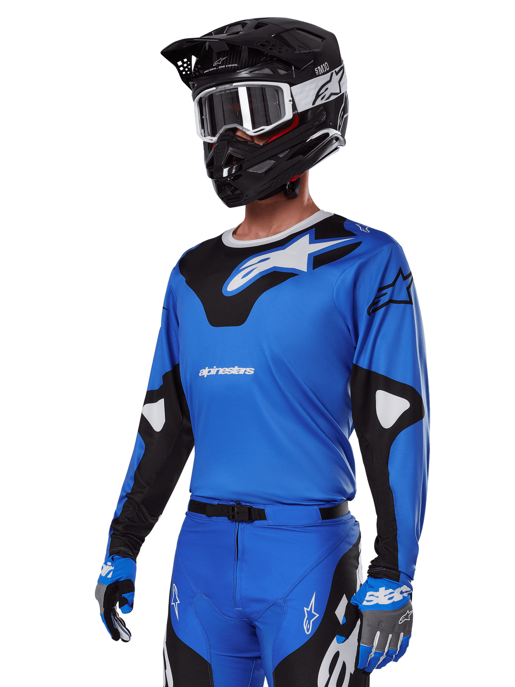 Alpinestars 2025 Racer Veil Gear Set, maglia da motocross blu con grafiche bianche e nere, indossata con pantaloni coordinati, casco nero, occhiali bianchi e guanti blu, abbigliamento tecnico per corse fuoristrada