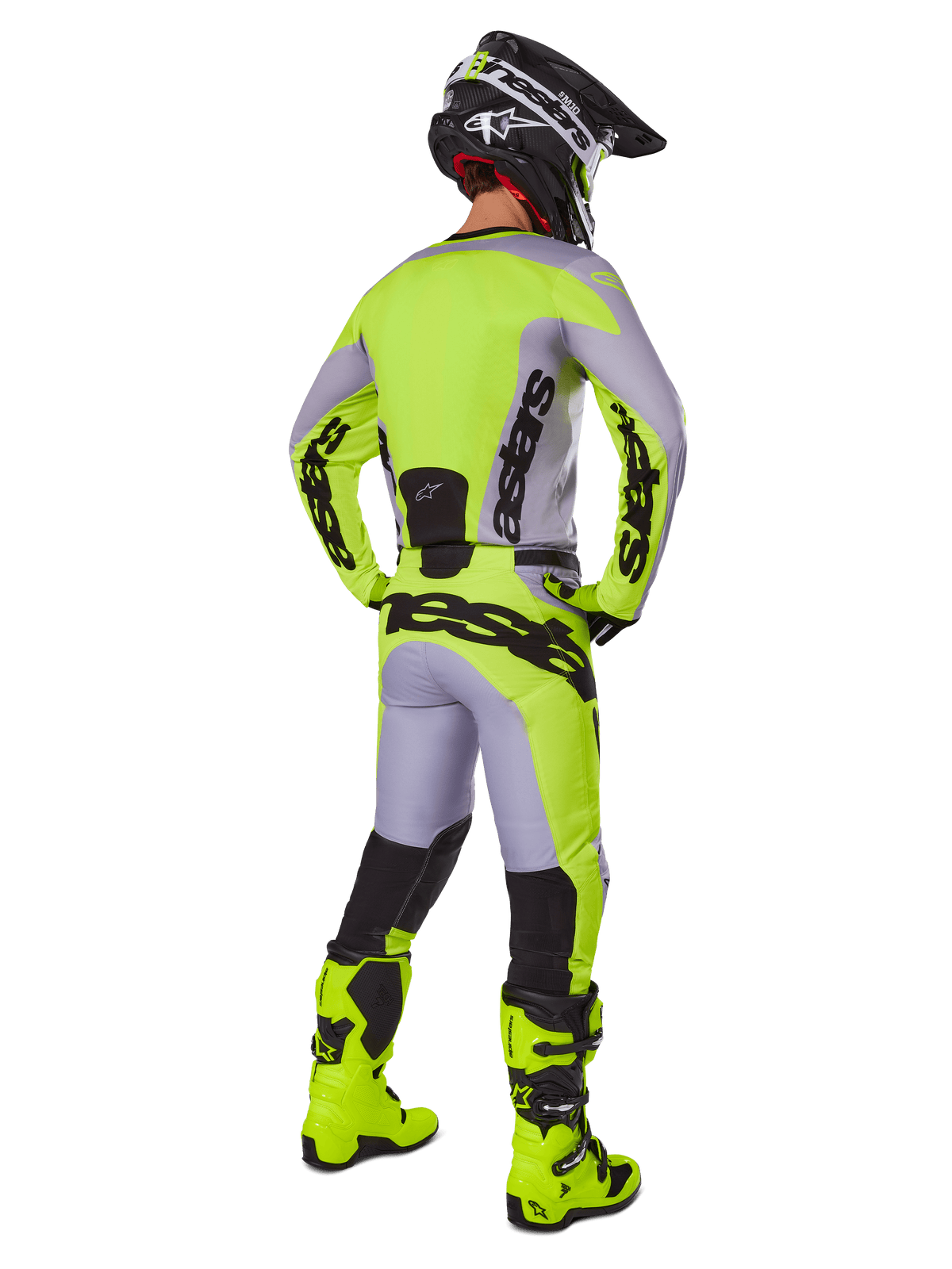Pilota di motocross visto di spalle con set Alpinestars Racer Veil Gear 2025, maglia e pantaloni grigi e giallo fluo, stivali giallo fluo abbinati e casco nero e giallo, completo coordinato per corse fuoristrada