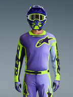 Alpinestars 2026 Racer Portl Gear Set, abbigliamento completo da motocross viola e verde lime, maglia viola con maniche giallo neon e logo Astar viola scuro, casco coordinato viola e verde con occhiali bianchi, pantaloni e guanti coordinati per il fuoristrada.