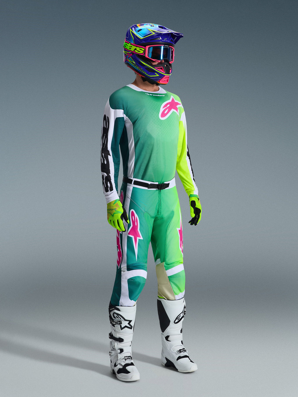 Set completo Alpinestars 2026 Racer Portl, pilota di motocross con maglia sfumata dal verde acqua al verde lime, loghi rosa e maniche bianche, pantaloni coordinati verde e bianco, casco con grafica colorata e maschera rosa, stivali bianchi e guanti giallo fluorescente, kit da gara professionale per fuoristrada
