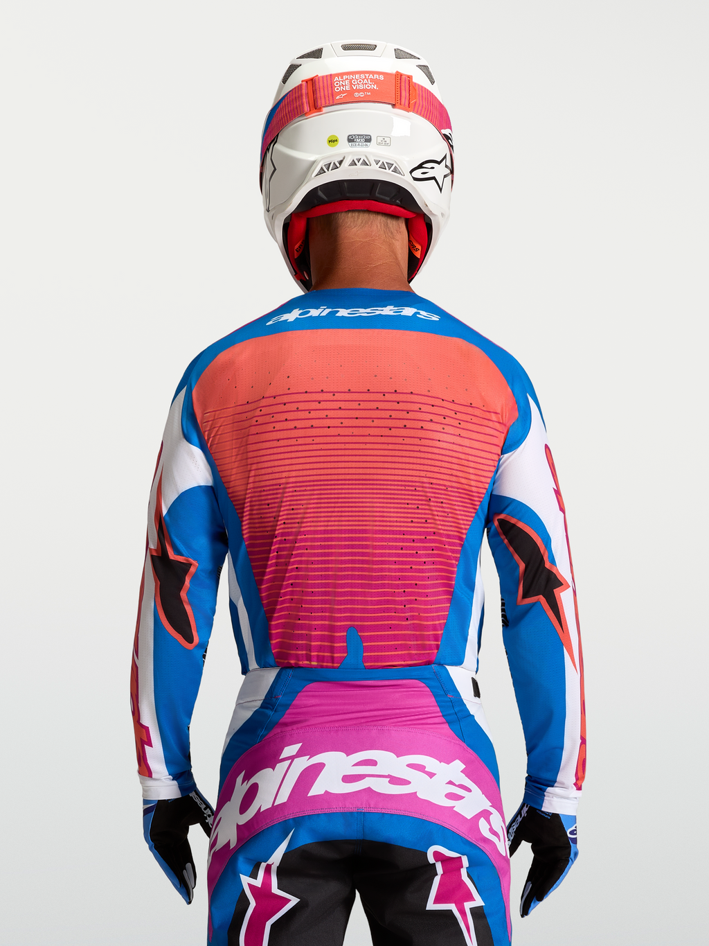 Alpinestars Maglia Techstar Maven, maglia da motocross per uomo, blu e arancione corallo, vista posteriore su pilota, vestibilità atletica con ventilazione laser