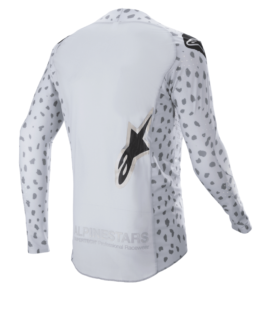 Alpinestars 2023 Supertech North Jersey, maglia da motocross, grigio Haze e nero, vista posteriore con motivo astratto a macchie su maniche e lati, grande logo a stella, pannello posteriore allungato e struttura traspirante ad alte prestazioni