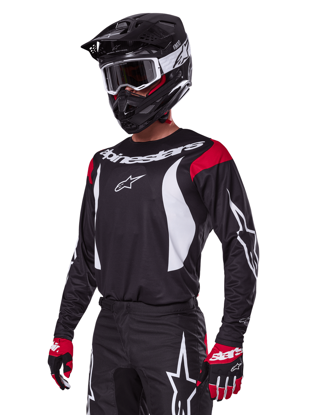 Pilota di motocross che indossa il set Alpinestars 2025 Fluid Haul, maglia nera con pannelli rossi sulle spalle e grafiche bianche, pantaloni neri coordinati con loghi a stella bianchi, guanti rossi e neri, casco nero con dettagli bianchi e occhiali, abbigliamento da motocross coordinato.