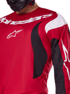 Maglia Alpinestars 2025 Fluid Haul, rosso acceso e nero, vista ravvicinata di petto e braccio con logo Alpinestars bianco, design ergonomico sportivo con accenti dinamici neri e bianchi per prestazioni da motocross.