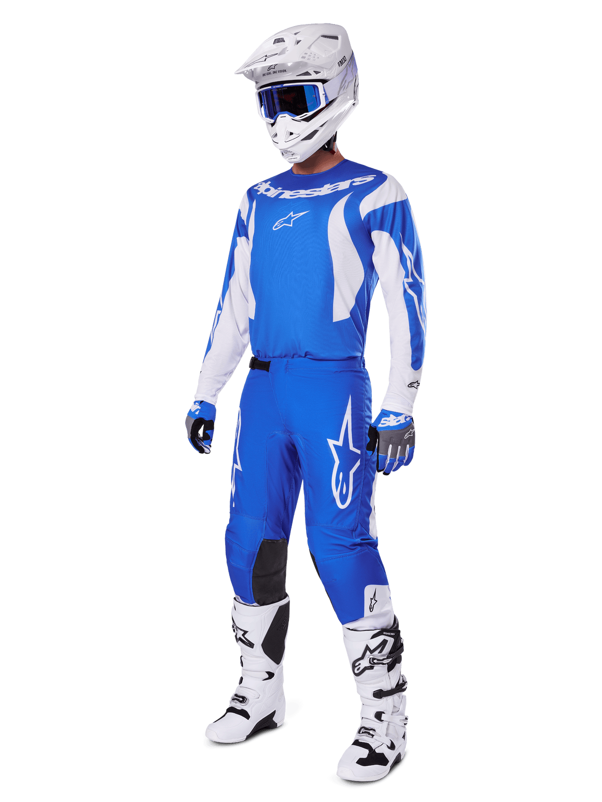 Pilota di motocross che indossa il set completo 2025 Fluid Haul, maglia e pantaloni blu e bianchi con logo Alpinestars, casco bianco con occhiali blu, stivali bianchi e guanti blu, completo da gara coordinato per motocross fuoristrada.