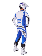 Pilota di motocross di spalle con completo Alpinestars 2025 Fluid Haul, maglia blu e bianca con pantaloni coordinati, casco bianco con dettagli blu e stivali da corsa bianchi e neri, abbigliamento da gara fuoristrada coordinato