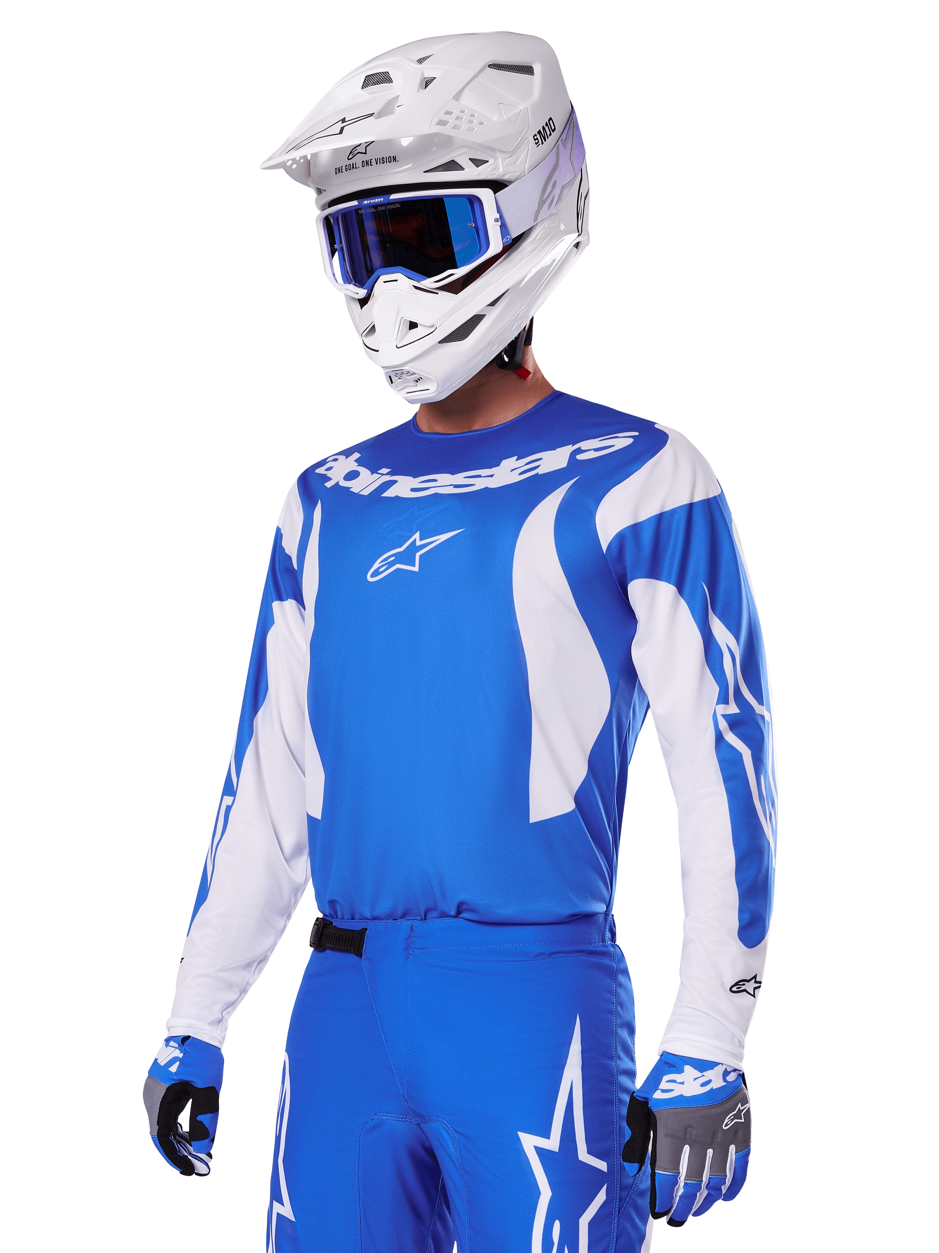 Pilota di motocross che indossa il set di abbigliamento Alpinestars 2025 Fluid Haul in blu e bianco, con maglia blu e accenti bianchi, pantaloni blu coordinati con loghi a stella, casco bianco con occhiali blu e guanti coordinati blu e grigi, outfit completo da gara off-road.