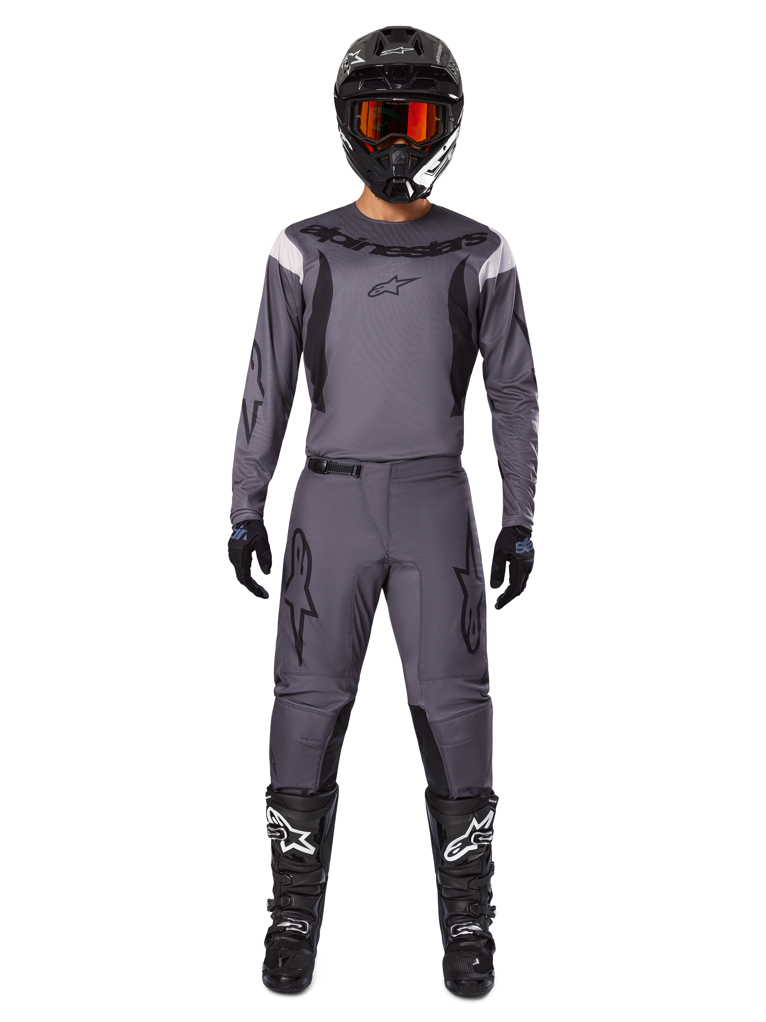 Alpinestars 2025 Fluid Haul Gear Set, abbigliamento da motocross, grigio, maglia e pantaloni grigi con dettagli neri, casco nero con occhiali arancioni, stivali neri con loghi bianchi, completo da gara coordinato per prestazioni fuoristrada