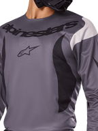 Alpinestars 2025 Fluid Haul Jersey, maglia da motocross, grigio con accenti neri e bianchi, con logo e scritta Alpinestars sul petto, vestibilità sportiva per gare off-road.