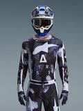 Alpinestars 2026 Racer Lahnd Jersey, maglia da motocross, motivo Iron Camo in bianco e nero, con grande logo a stella e scritta ASTARS, indossata con pantaloni coordinati e casco da motocross blu