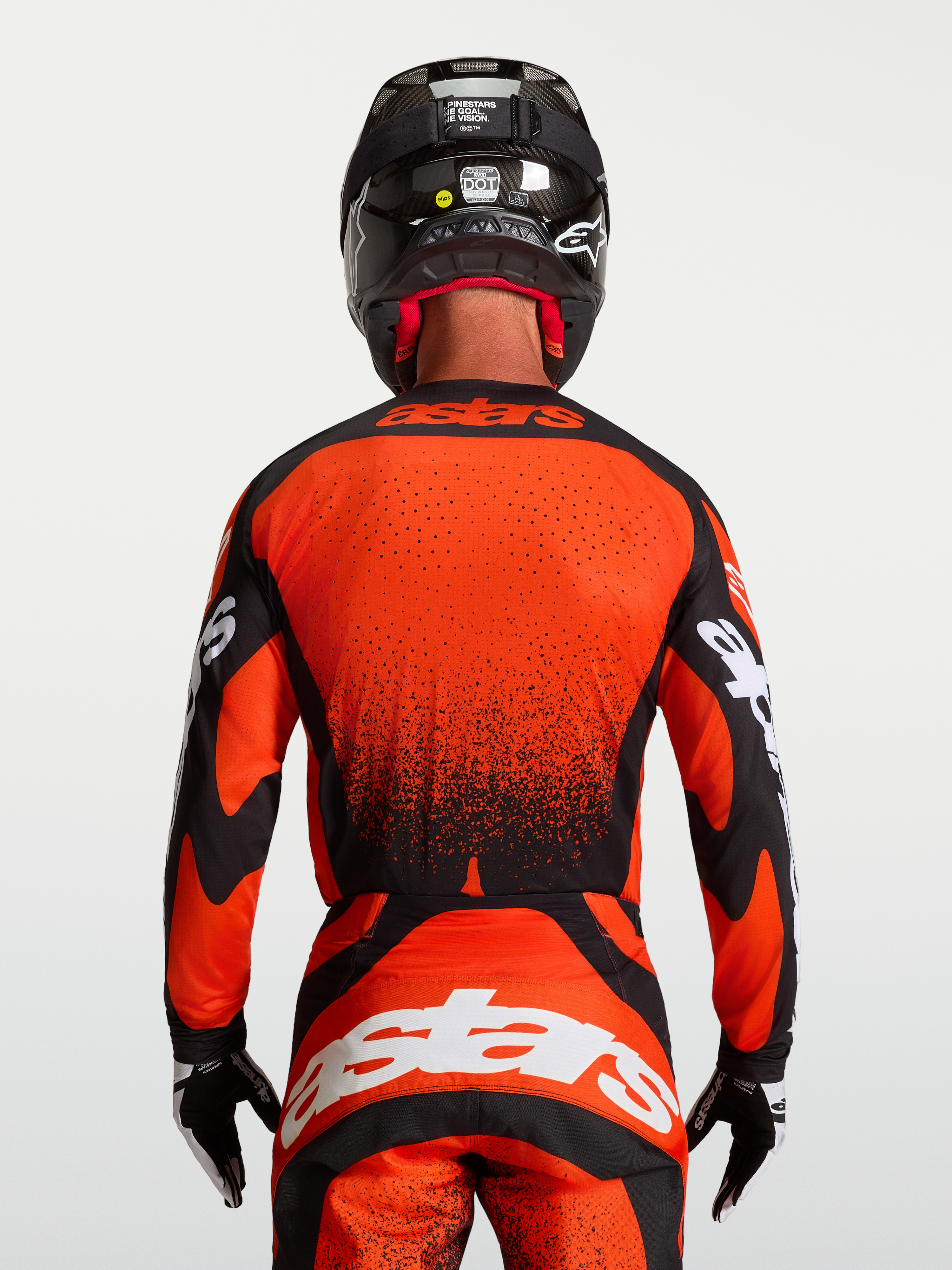 Alpinestars Maglia Techstar Swan, maglia motocross rossa e nera, vista posteriore su modello, orlo allungato con perforazioni laser, stile racing