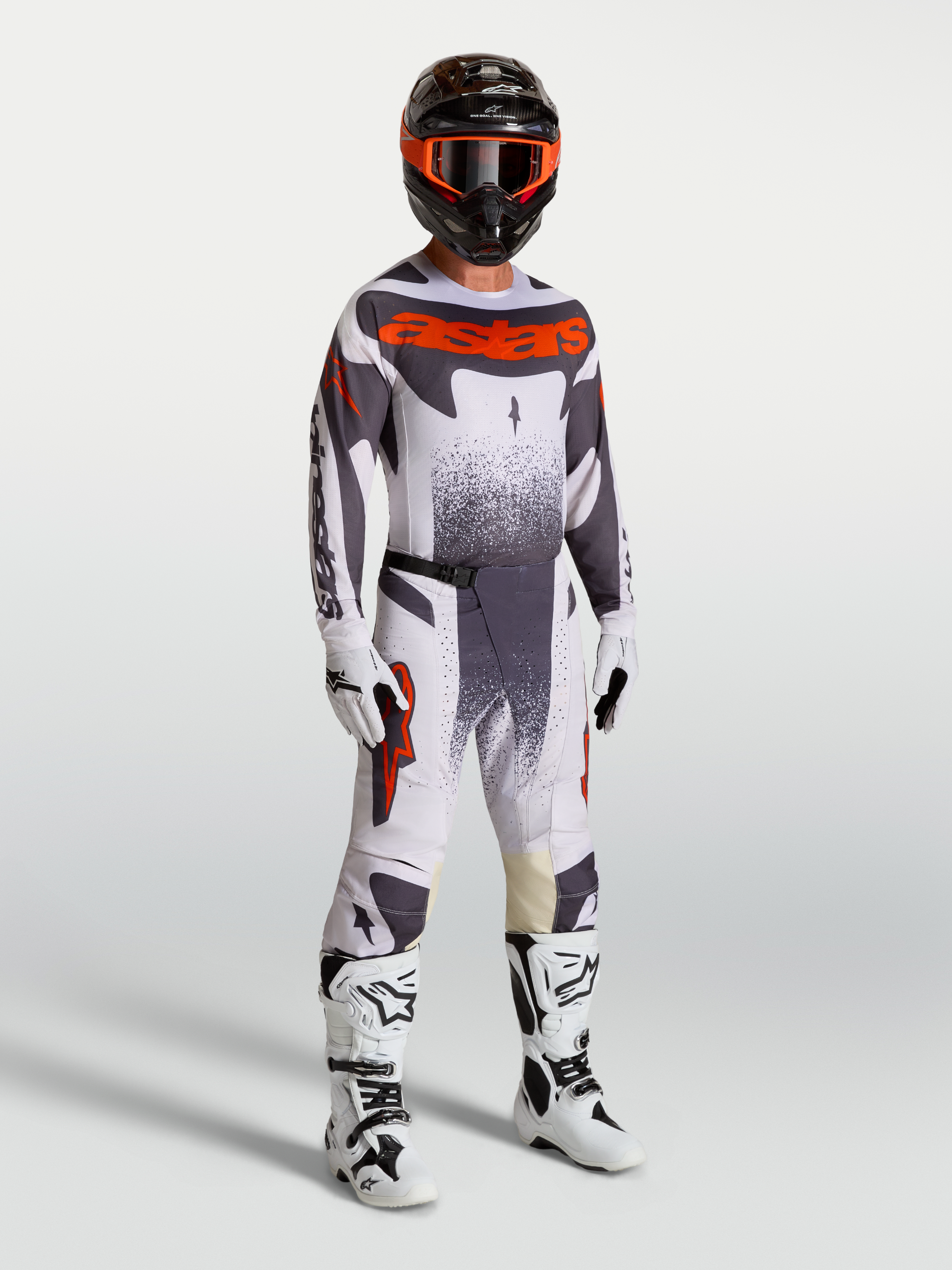 Alpinestars maglia e completo Techstar Swan, abbigliamento motocross da uomo su modello lilla e grigio con rosso fluo.